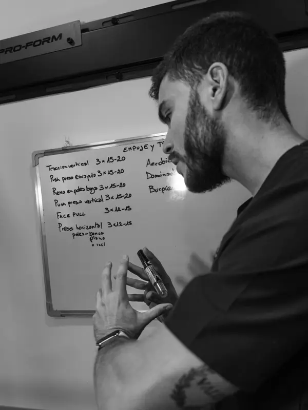 Fisioterapeuta de Invicto planificando las fases de un programa de rehabilitación en la pizarra