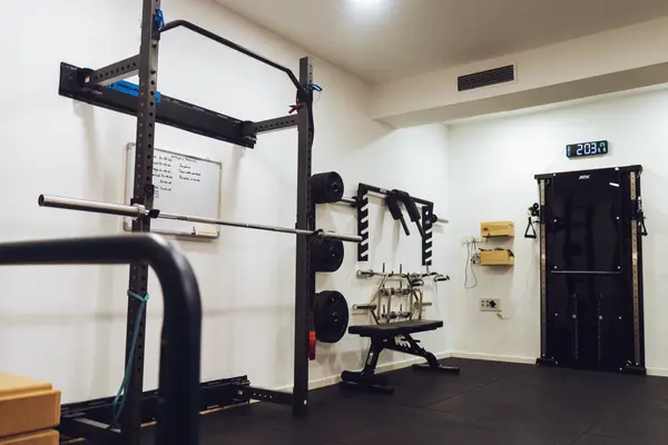 Sala de rehabilitación de Invicto en Granada con rack, poleas y material de fuerza
